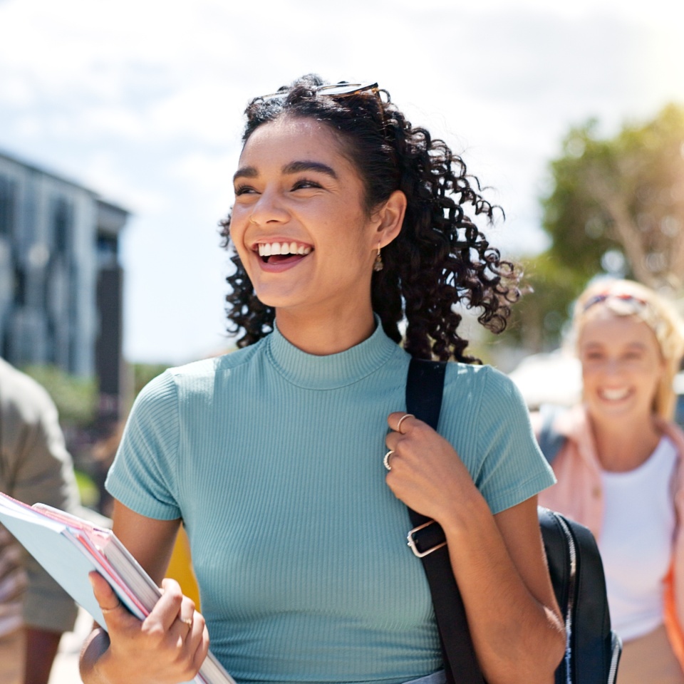 Walking, happy and girl with friends at university for learning, bonding and talking with fun. People, school and group of gen z students commuting outdoor ready for education at college campus.